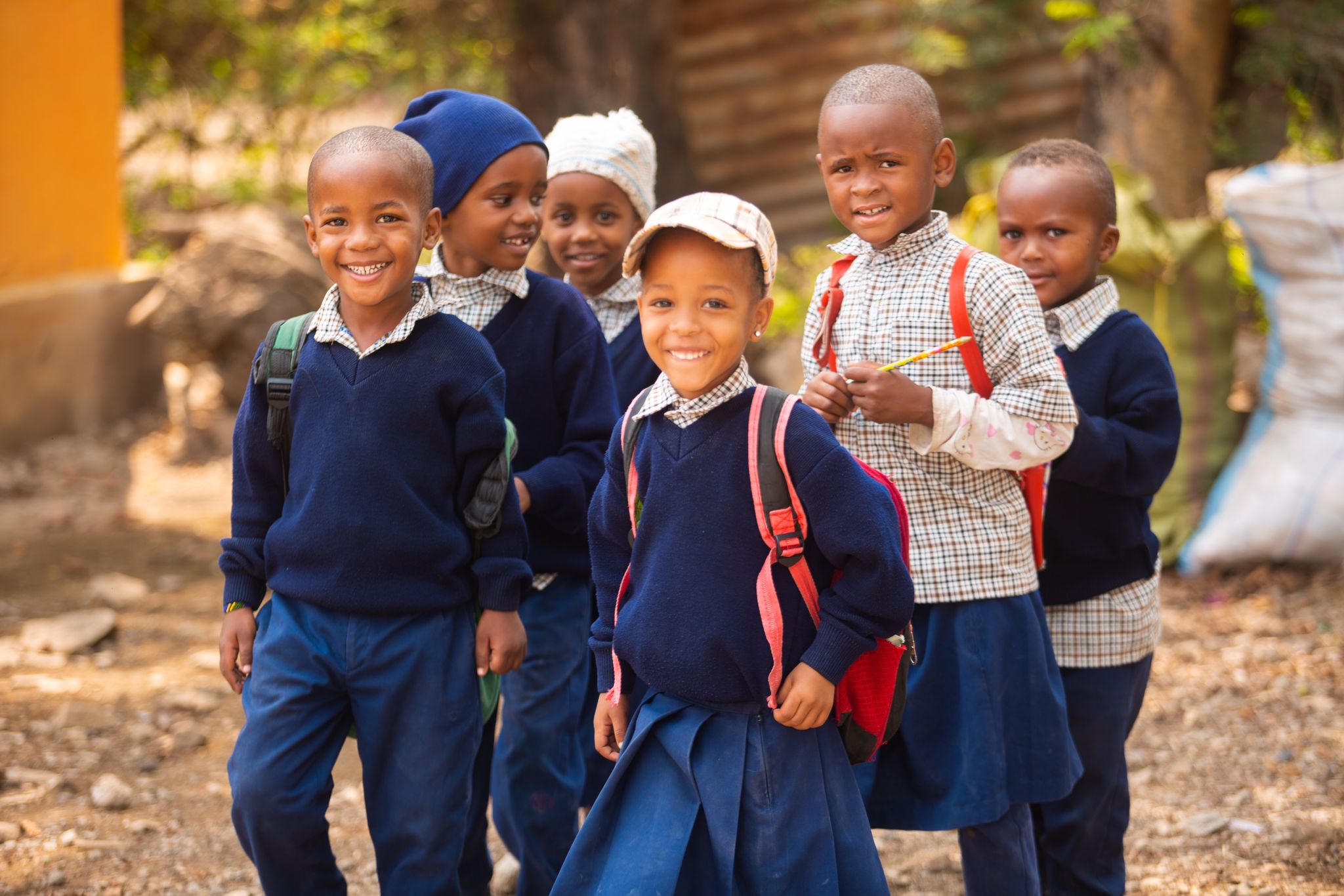 Barn i uniform som smiler på en skole i Tanzania